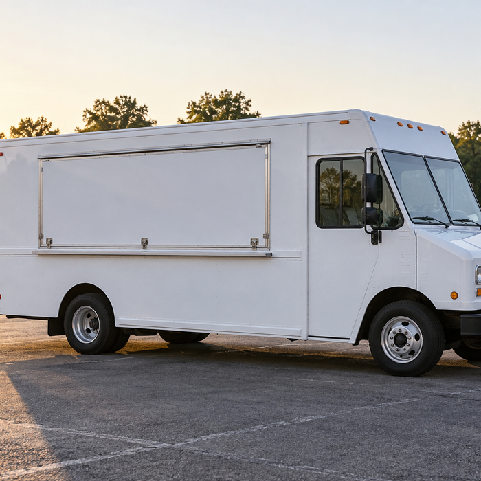 An unbranded food-service truck parked with its serving hatch closed and no cooking equipment visible.